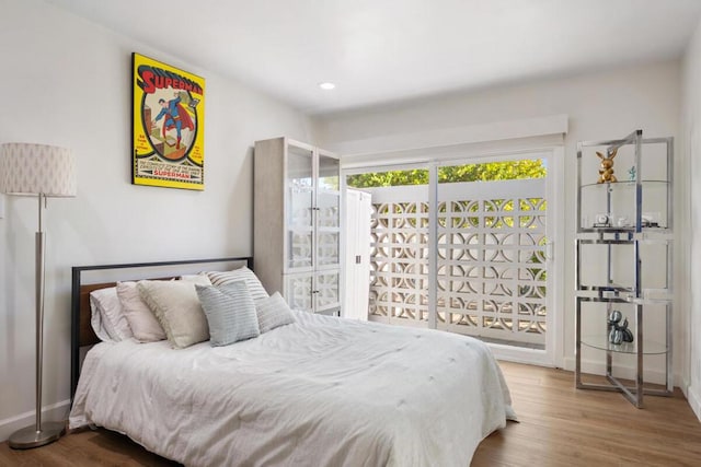 bedroom with access to outside and hardwood / wood-style floors