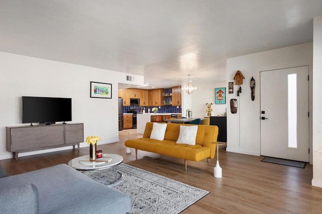 living room with an inviting chandelier and hardwood / wood-style flooring