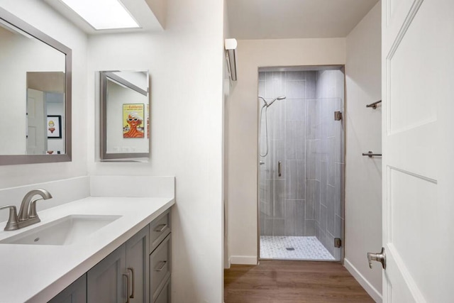 bathroom with vanity, hardwood / wood-style floors, and a shower with shower door