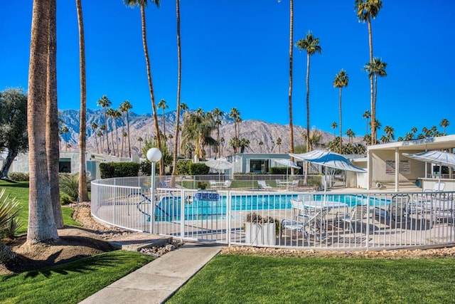 view of pool with a mountain view, a lawn, and a patio area