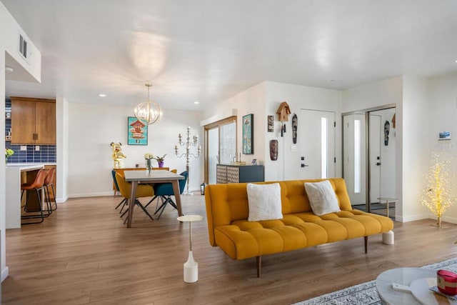 living room featuring an inviting chandelier and light hardwood / wood-style flooring