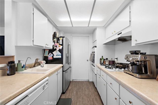 kitchen featuring white appliances, white cabinetry, dark hardwood / wood-style flooring, and sink