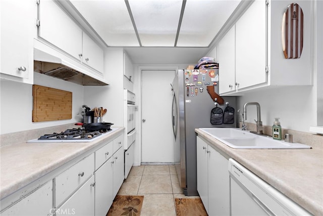 kitchen featuring light tile patterned floors, appliances with stainless steel finishes, sink, and white cabinetry