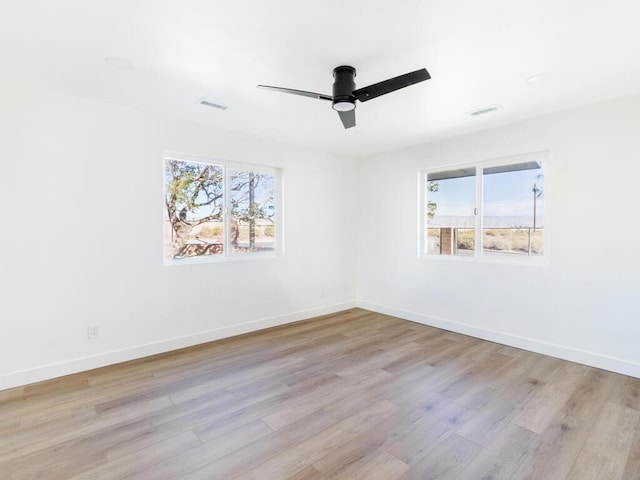 empty room with ceiling fan and light hardwood / wood-style flooring