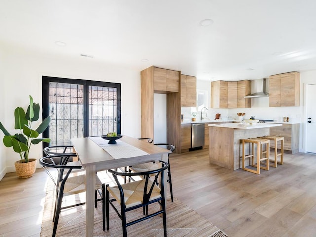 dining room with sink and light hardwood / wood-style floors