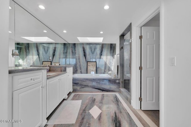 bathroom with vanity, a skylight, and independent shower and bath