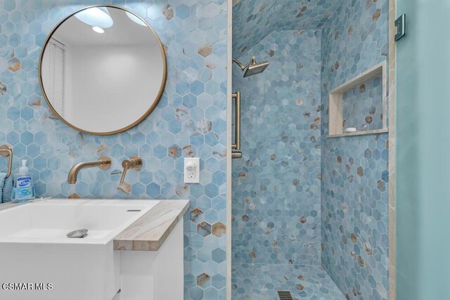 bathroom with vanity and a tile shower