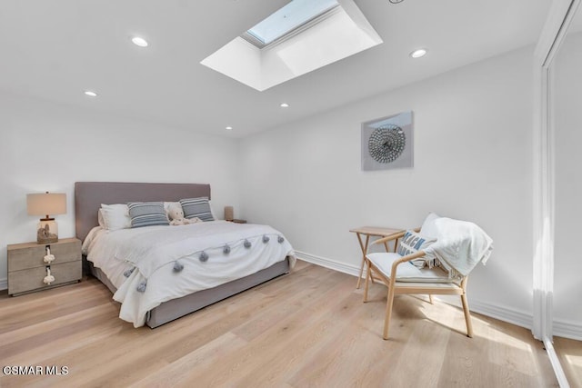 bedroom featuring a skylight and light wood-type flooring