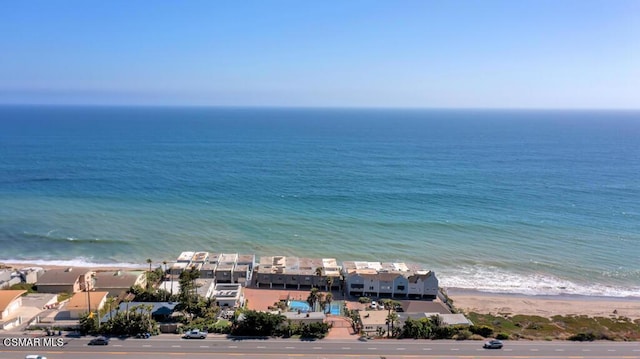 birds eye view of property with a water view and a beach view