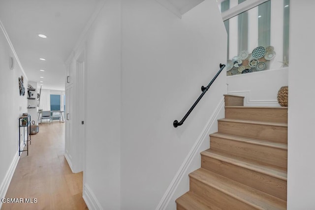 stairway with crown molding and hardwood / wood-style flooring