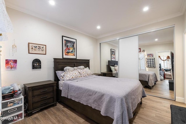 bedroom featuring a closet, ornamental molding, and light hardwood / wood-style flooring