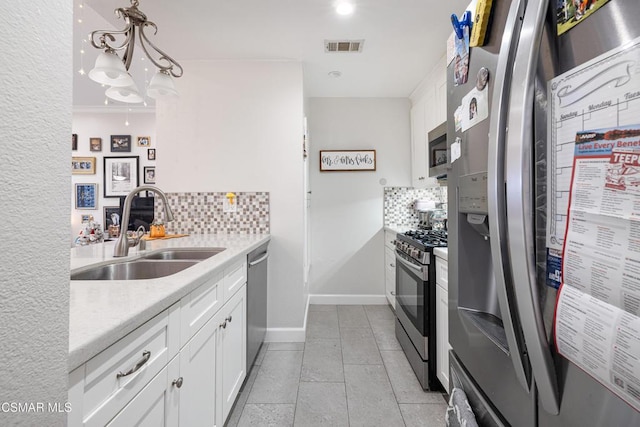 kitchen featuring decorative backsplash, sink, stainless steel appliances, and white cabinetry