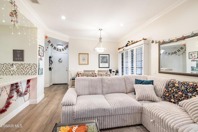 living room featuring crown molding and light hardwood / wood-style flooring