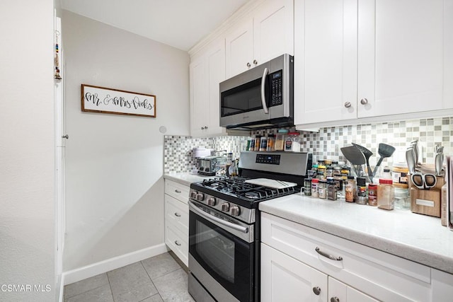 kitchen featuring white cabinets, decorative backsplash, appliances with stainless steel finishes, and light tile patterned flooring