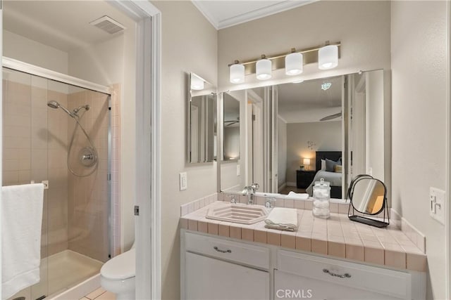 bathroom featuring an enclosed shower, vanity, toilet, and ornamental molding