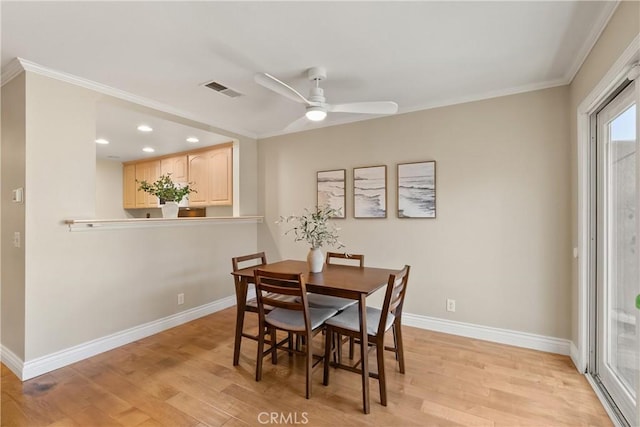 dining room with ceiling fan, ornamental molding, and light hardwood / wood-style floors