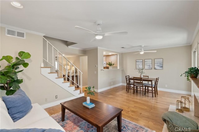 living room with ceiling fan, wood-type flooring, and crown molding