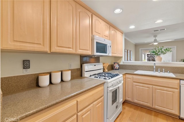 kitchen with light hardwood / wood-style floors, ceiling fan, light brown cabinets, white appliances, and sink