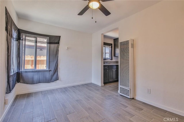 unfurnished room with light wood-type flooring, ceiling fan, and sink