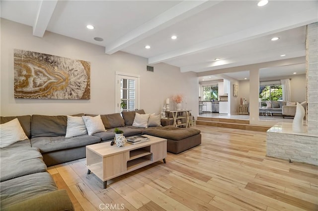 living room with light wood finished floors, beam ceiling, and recessed lighting