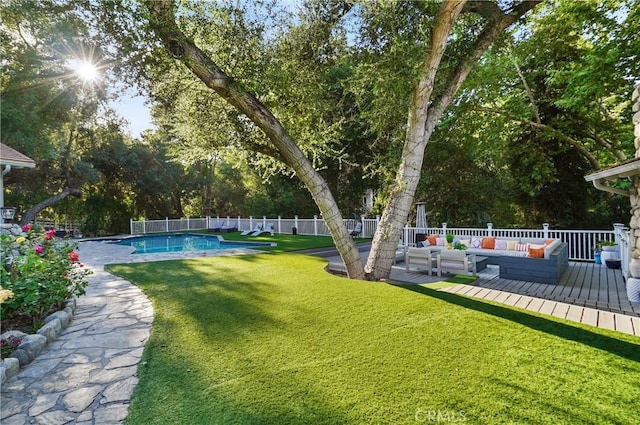 view of yard featuring an outdoor hangout area, a deck, fence, and a fenced in pool