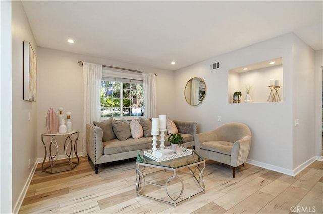 living area featuring light wood finished floors, baseboards, visible vents, and recessed lighting