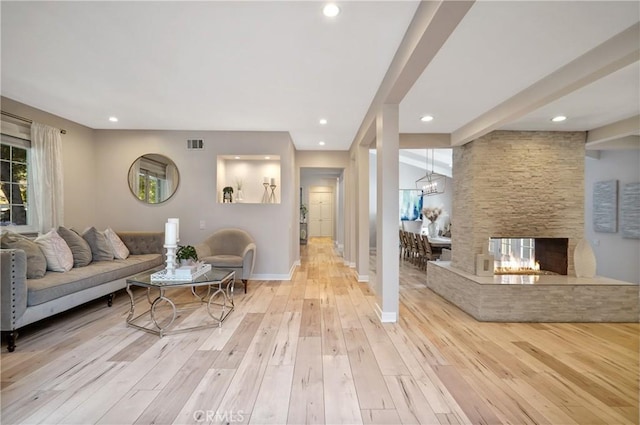 living area with recessed lighting, a fireplace, visible vents, baseboards, and light wood-type flooring