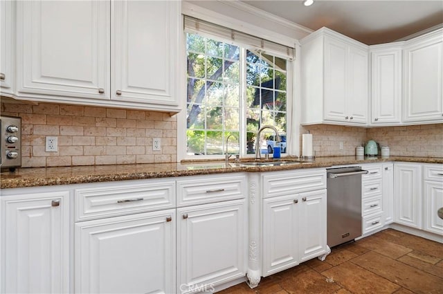 kitchen featuring backsplash, dark stone countertops, a sink, and white cabinetry