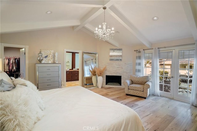 bedroom with lofted ceiling with beams, access to outside, a stone fireplace, and light wood-style floors