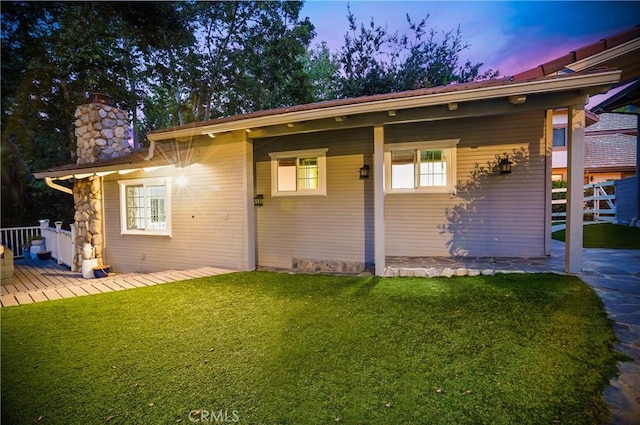 exterior space with a chimney and a yard