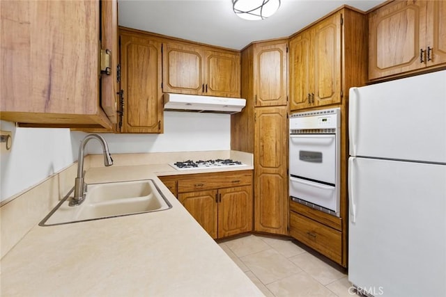 kitchen with sink, white appliances, and light tile patterned floors