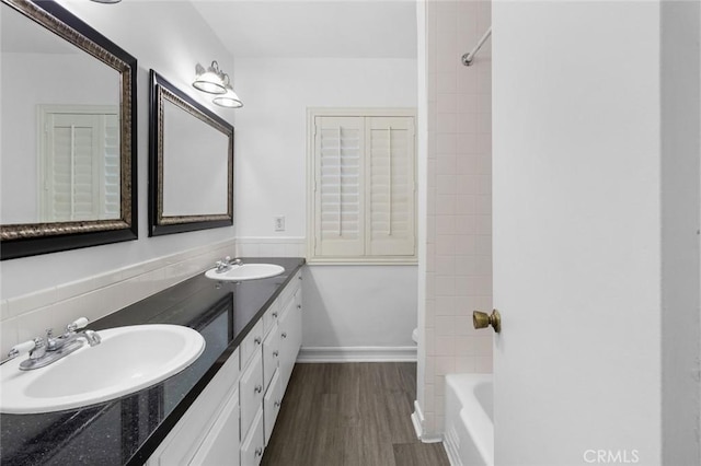 bathroom featuring hardwood / wood-style flooring, tiled shower / bath combo, and vanity