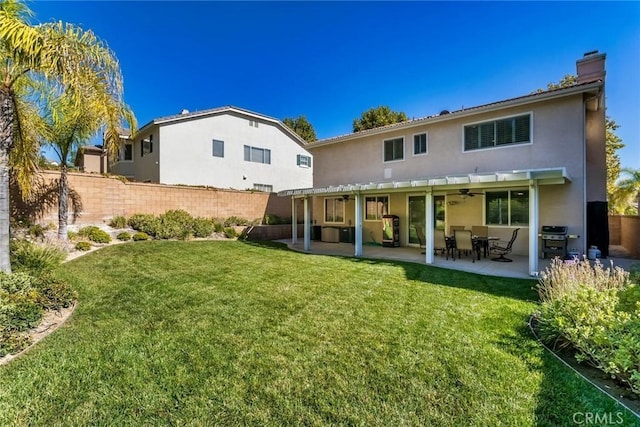 rear view of property with a yard and a patio