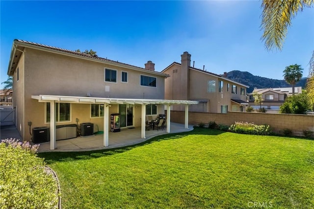 rear view of property featuring central AC unit, a patio, a yard, and a pergola