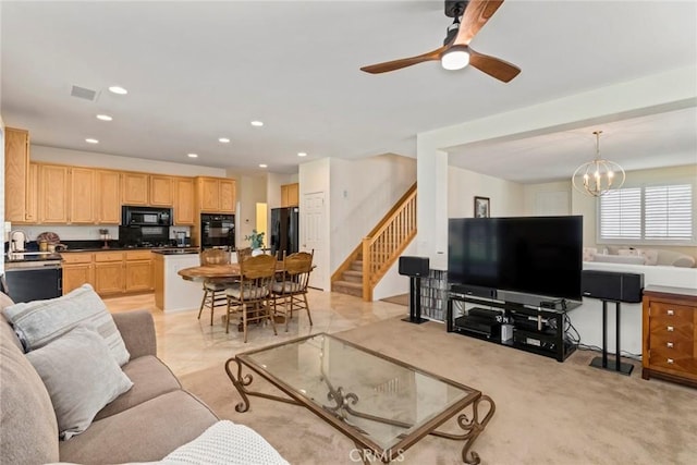 carpeted living room featuring ceiling fan with notable chandelier and sink