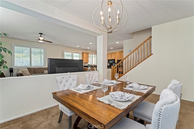 carpeted dining room with ceiling fan with notable chandelier