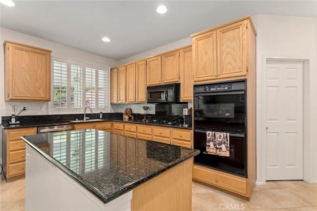 kitchen with a kitchen island, black appliances, sink, light brown cabinetry, and dark stone counters