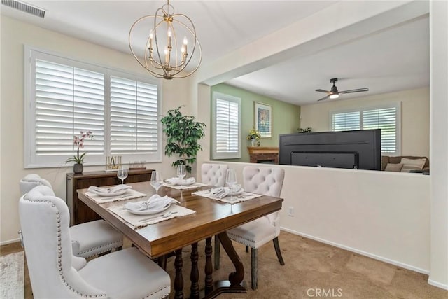 dining area with light carpet and ceiling fan with notable chandelier