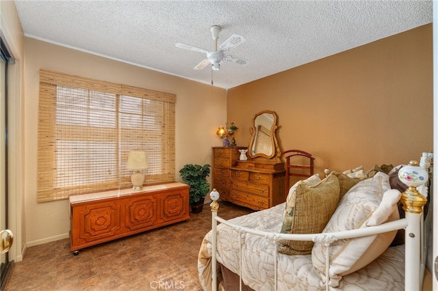 bedroom with ceiling fan and a textured ceiling