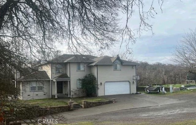 traditional-style home with a garage and aphalt driveway