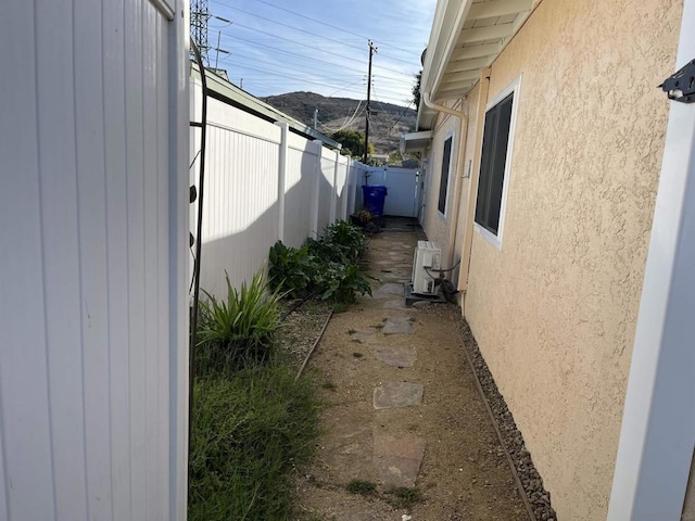 view of side of home featuring a mountain view and ac unit