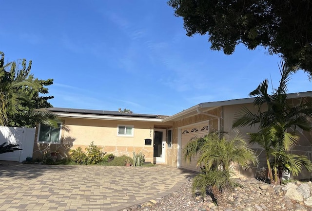 view of front of house featuring a garage and solar panels