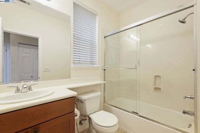 full bathroom with toilet, enclosed tub / shower combo, and vanity