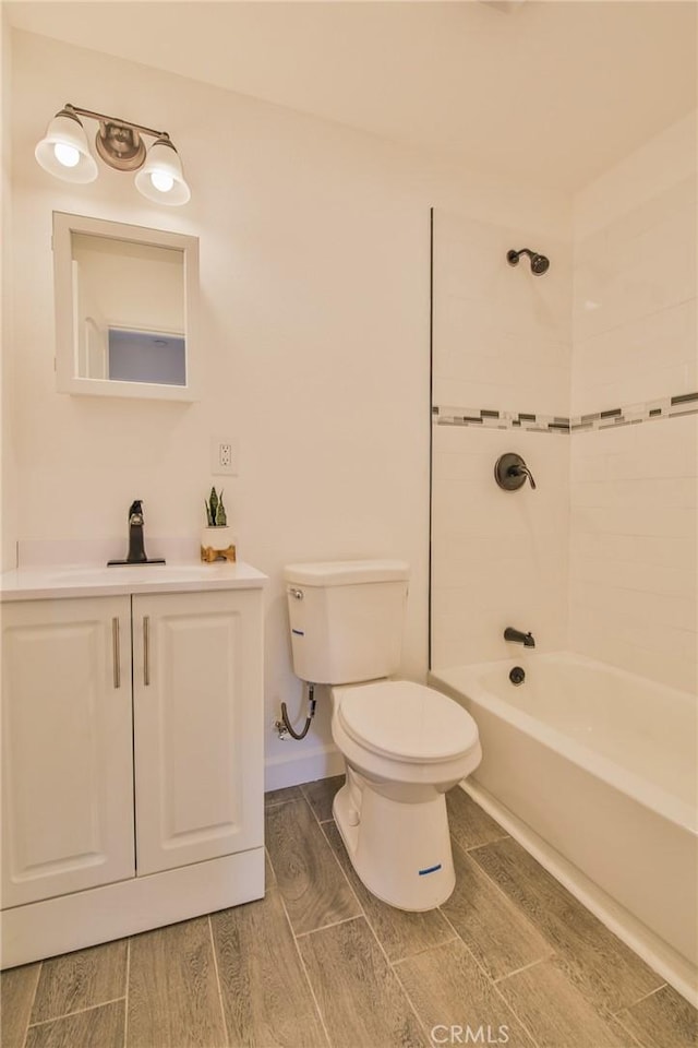 full bathroom with tiled shower / bath combo, vanity, and toilet