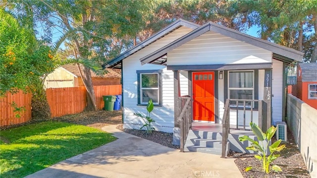 bungalow featuring a front yard and cooling unit