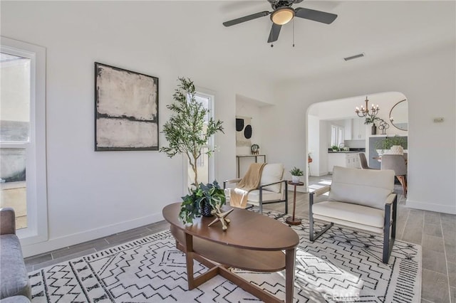 living room featuring ceiling fan with notable chandelier