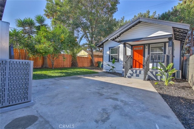 view of front of house with a front lawn and central AC