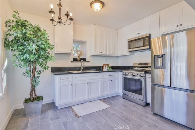 kitchen with pendant lighting, sink, stainless steel appliances, white cabinets, and a chandelier