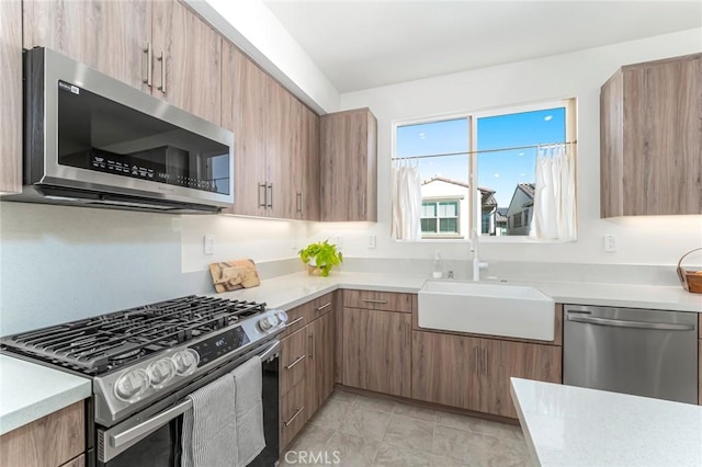 kitchen with light tile patterned flooring, appliances with stainless steel finishes, and sink