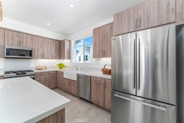 kitchen with light tile patterned floors, appliances with stainless steel finishes, and sink